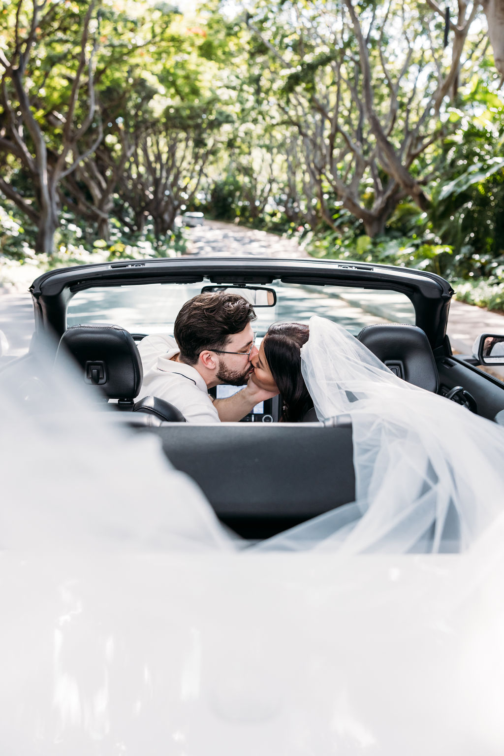 Real-wedding-helena-david-hawaii-pre-ceremony-portrait-bride-and-groom-kiss-car-convertible-transport