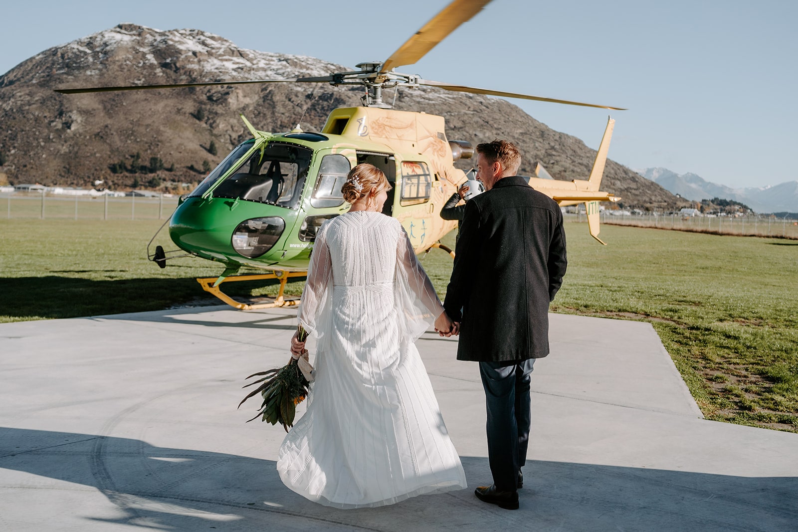 Real-wedding-Katie-and-Ben-New-Zealand-couple-walking-towards-the-helicopter