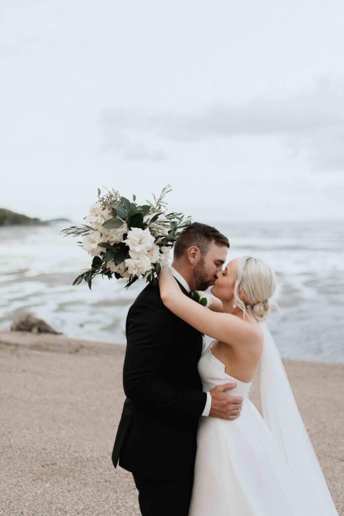 Real-wedding-Teagan-and-Luke-Villa-Botanica-Whitsundays-Australia-by-Rolling-Portraits-newlywed-portrait-post-ceremony-reception-area-beach-shore-kiss