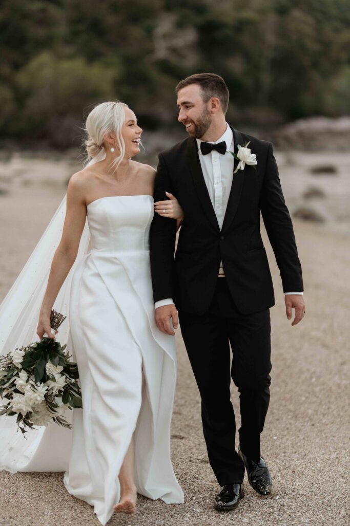 Real-wedding-Teagan-and-Luke-Villa-Botanica-Whitsundays-Australia-by-Rolling-Portraits-newlywed-portrait-post-ceremony-reception-area-bride-and-groom-walking-on-the-beach-shore