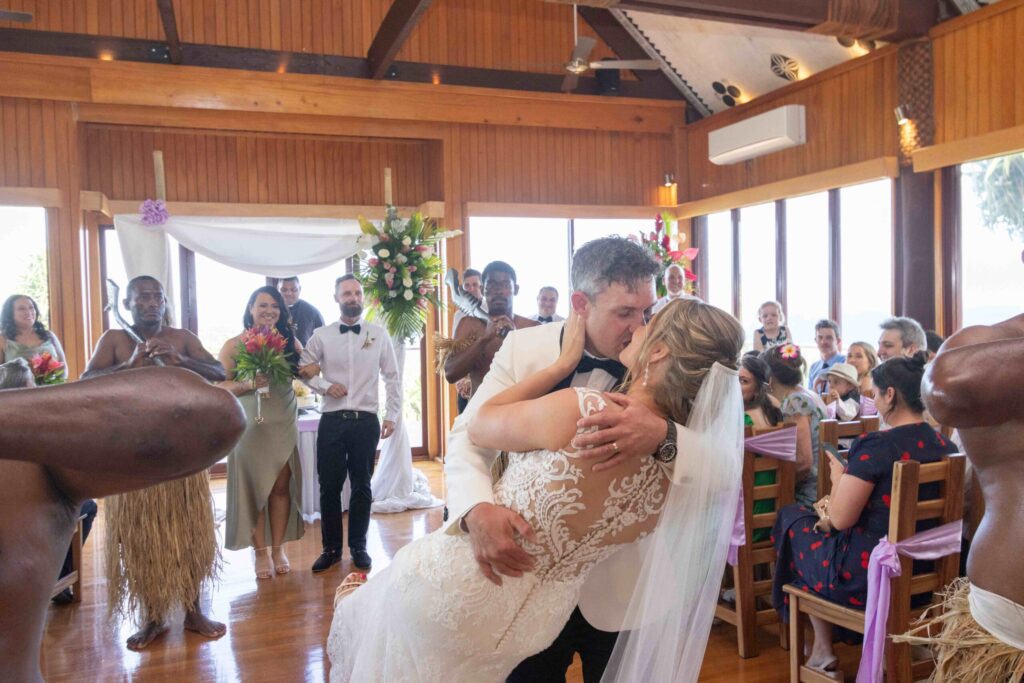 Kylee & Jason at Outrigger Fiji Beach Resort - images by Ocean Studio Fiji - bride and groom kissing on the aisle
