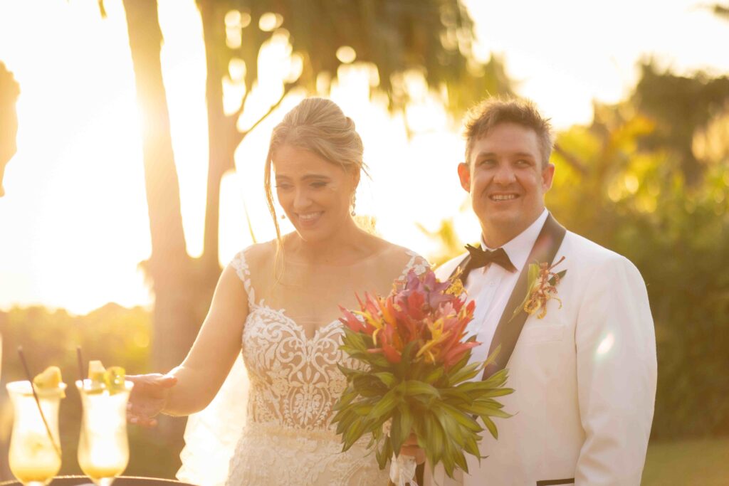 Kylee & Jason at Outrigger Fiji Beach Resort - images by Ocean Studio Fiji - bride and groom walking during sunset holding flowers
