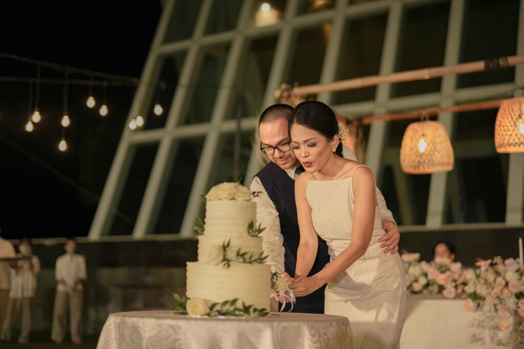 Real Wedding - Conrad Bali - Tressabel and Yovan - newlyweds slicing the cake